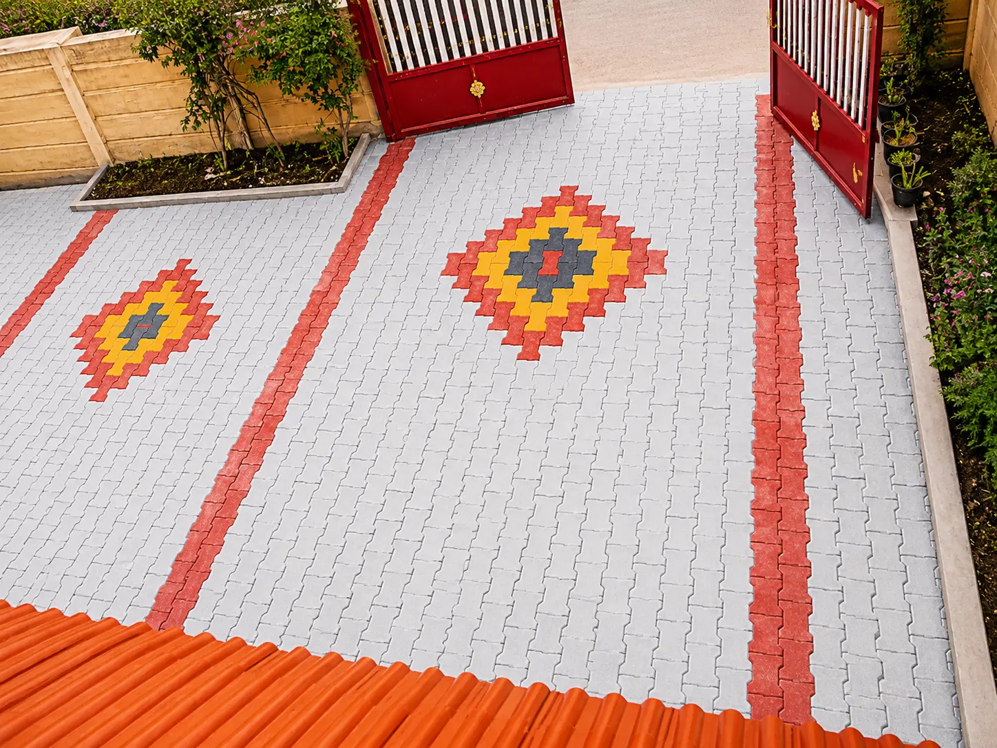 Gated entrance courtyard in grey zig zag pavers with red bands and diamond motifs