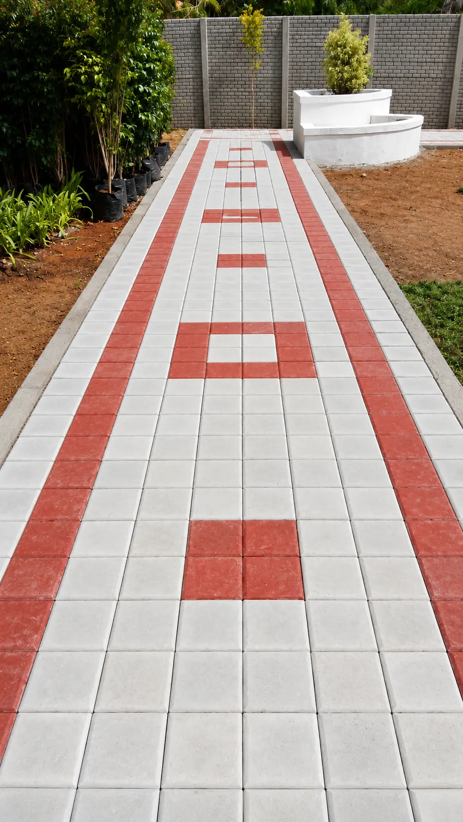 Garden walkway of white square pavers with red border lines and red square motifs