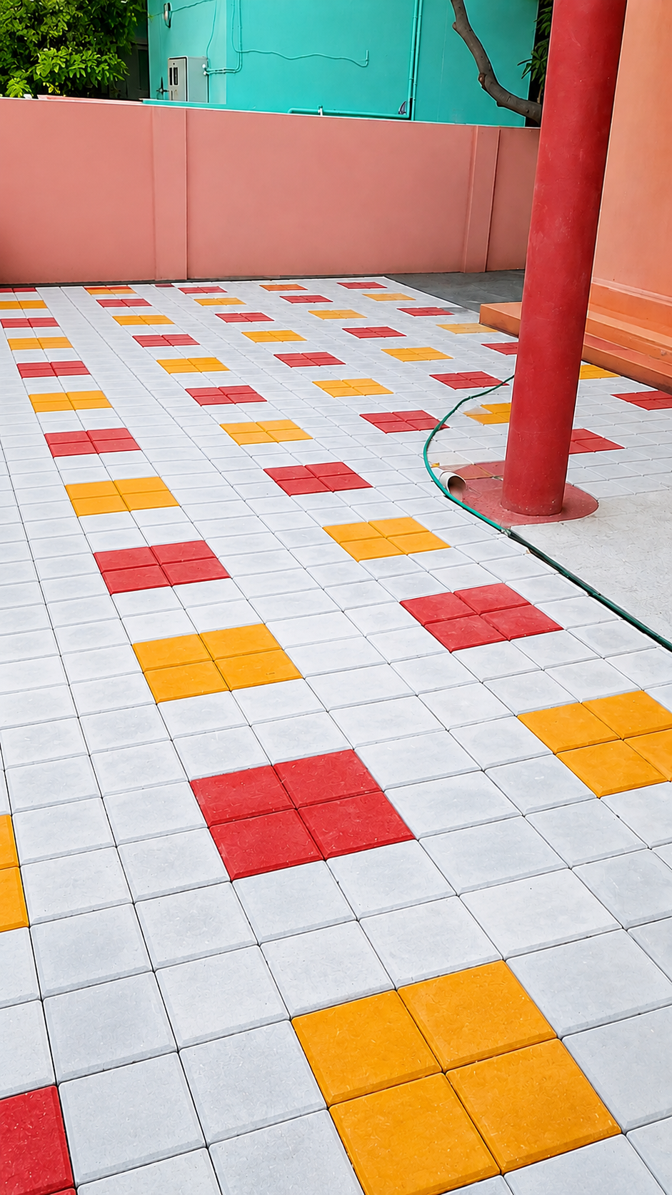 Courtyard of white square pavers with red and yellow square accents